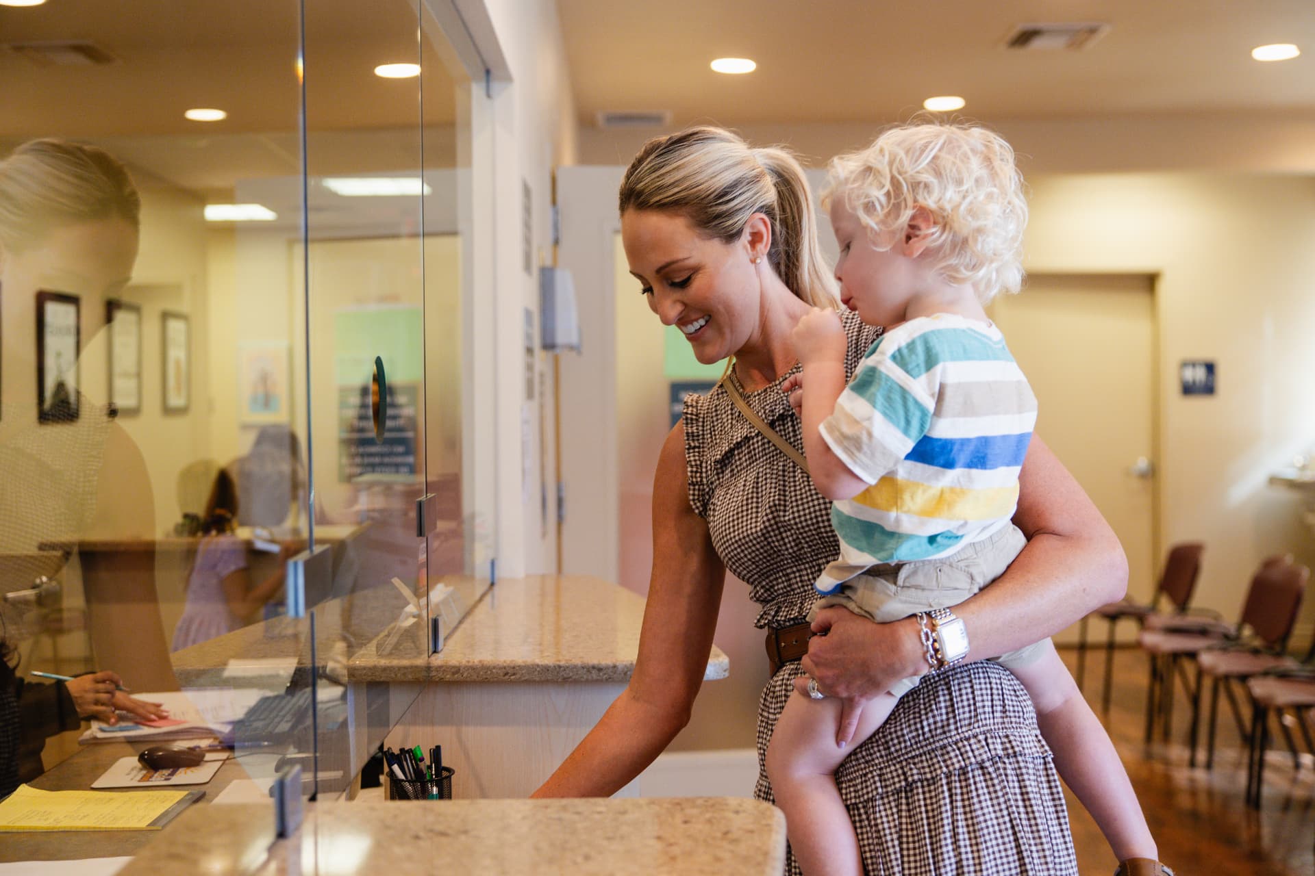 Parent holding her child at the reception desk inside Sun City Kidz Clinic